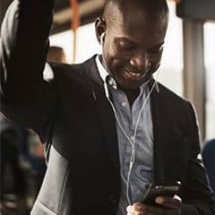 african american man listens to podcast while riding bus